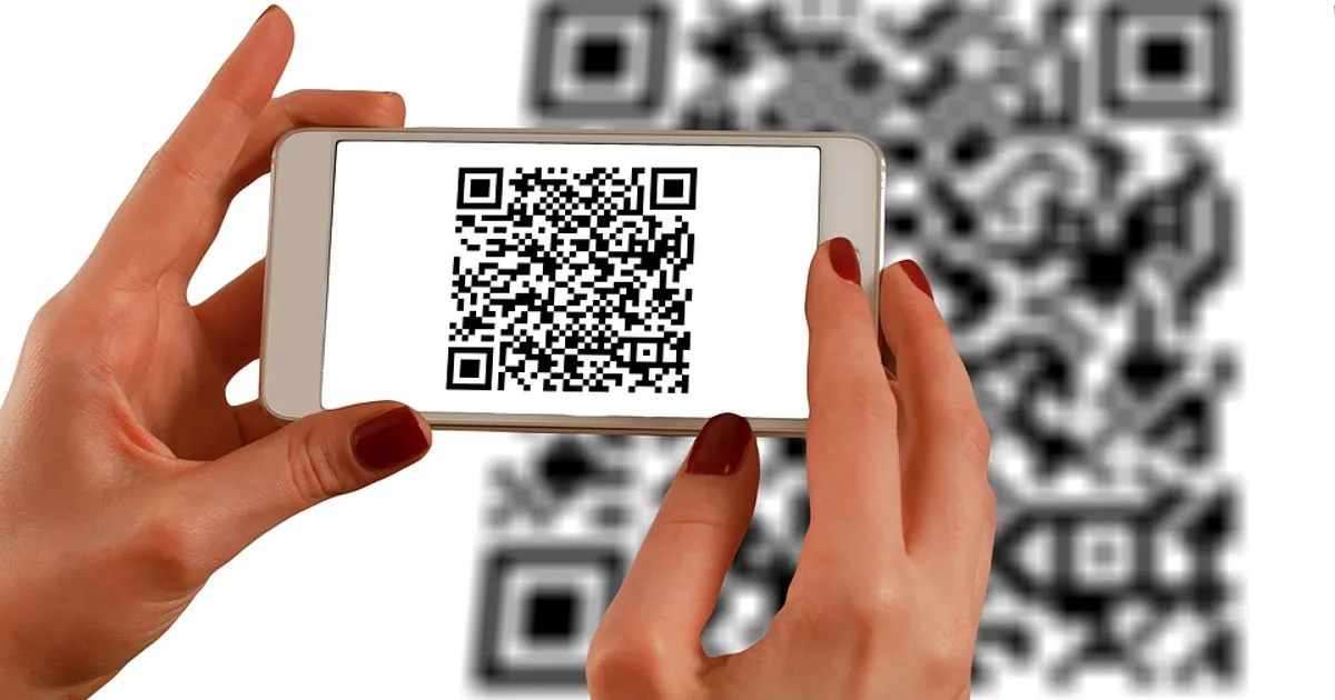 Hand scanning a QR code with a smartphone