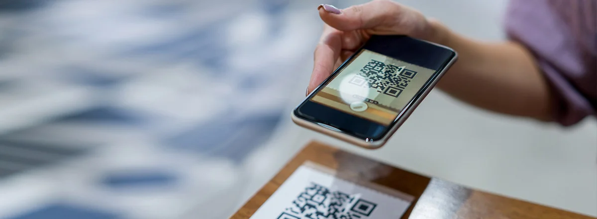 Someone scanning a printed QR code with a phone